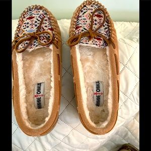 Minnetonka fur lined moccasins with crossstitching on the toe. Leather laced 8W